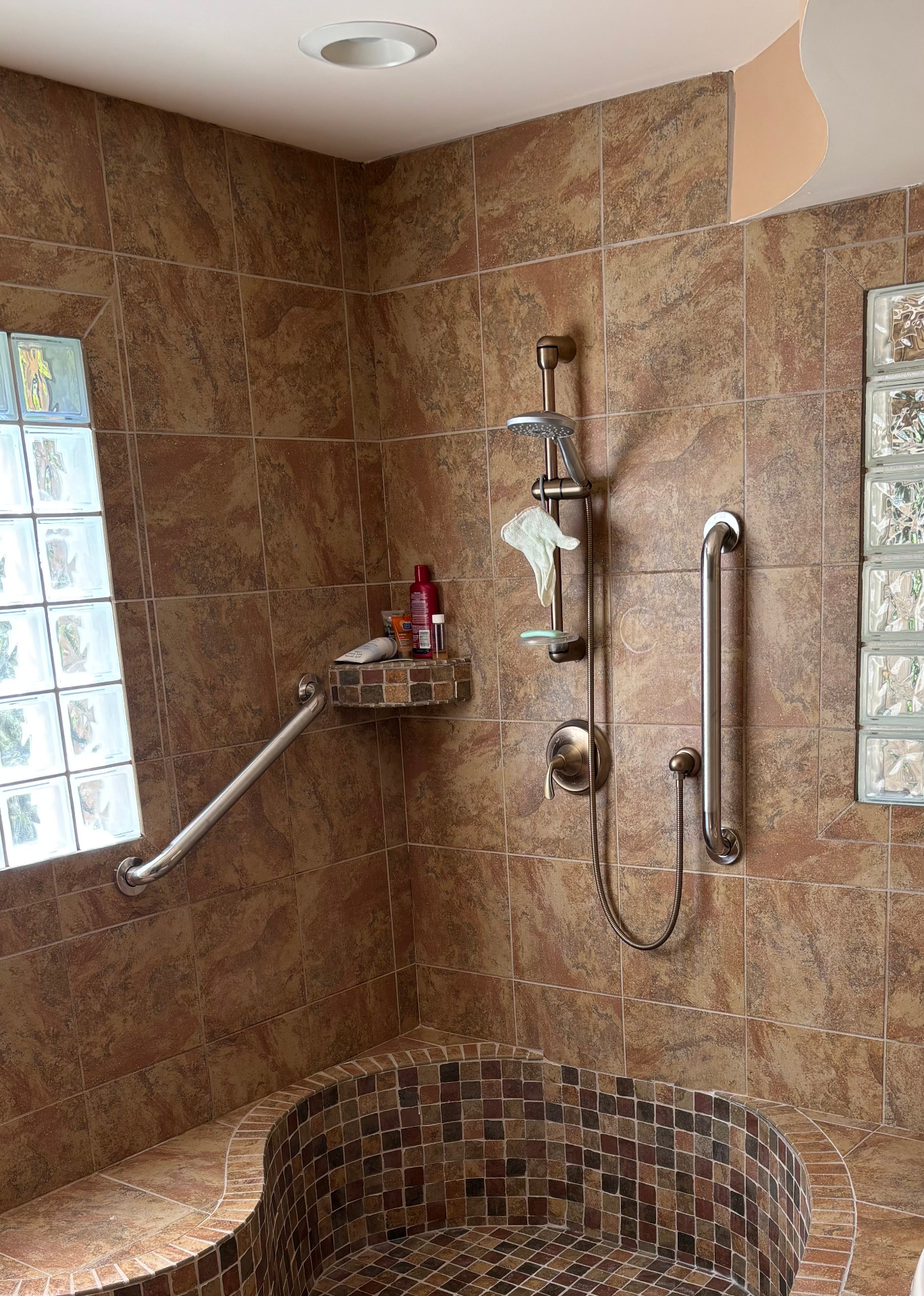 Stainless steel grab bar installed in a tiled shower