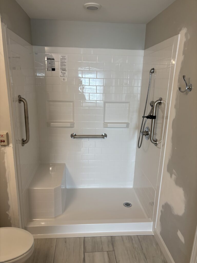This shower features grab bars, and to be more wheelchair accessible, there are no shower doors. A built-in shower seat offers further security for senior citizens.